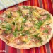 Pizza de carpaccio, rúcula y piñones