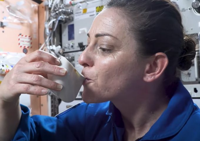 Beber en una taza de gravedad cero en el espacio